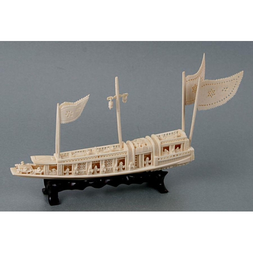 624 - An early 20th century Chinese carved ivory ceremonial barge on a hardwood stand, 26cms long.