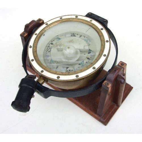 63 - An H Hughes & Son London gimbled brass ship's compass, 25cms diameter, on an oak stand, 40cms wi... 