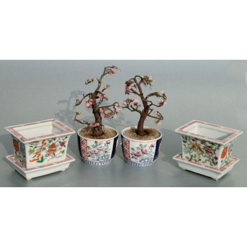 631 - A pair of rectangular form Chinese famille rose planters on stands decorated with precious objects, ... 