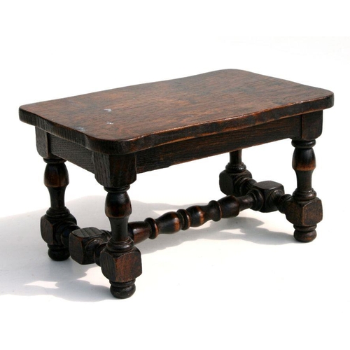 664 - A miniature oak stool on turned legs joined by a stretcher.