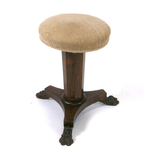 686 - An early 19th century rosewood revolving piano stool on tapering octagonal column and tripod base wi... 