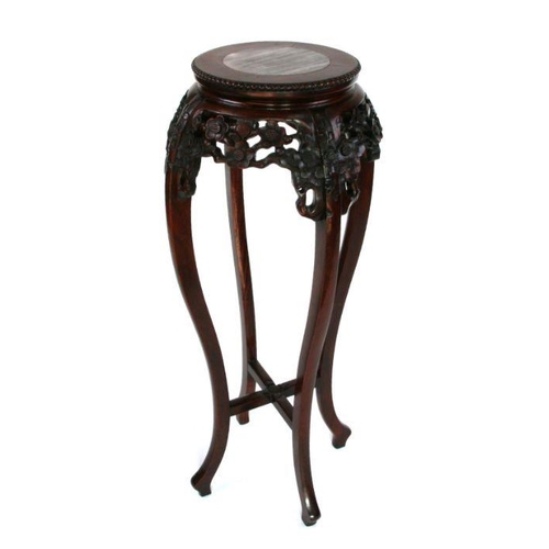 687 - A Chinese hardwood plant stand with inset figured marble top and pierce prunus frieze.