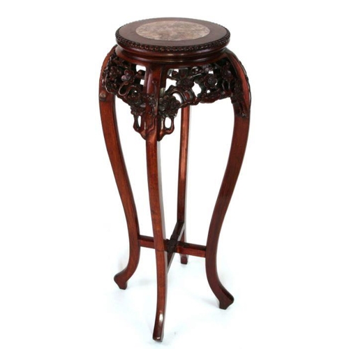 688 - A Chinese hardwood plant stand with inset figured marble top and pierce prunus frieze.