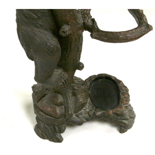 698 - A 20th century Black Forest carved bear hallstand, the adult bear climbing the tree and looking up a... 