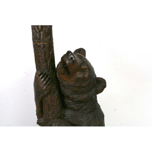 698 - A 20th century Black Forest carved bear hallstand, the adult bear climbing the tree and looking up a... 