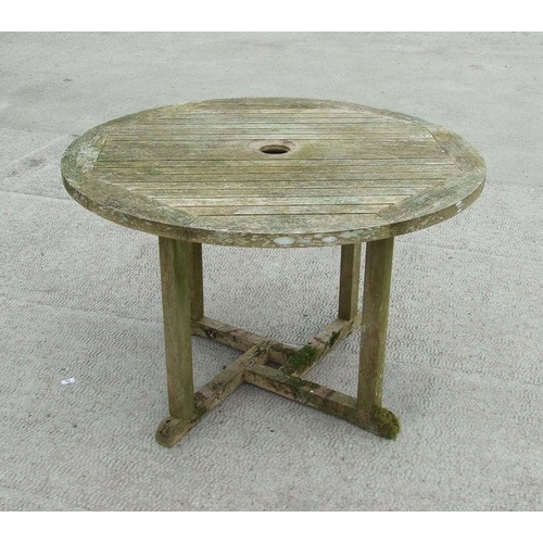 7 - A well weathered teak circular garden table, 109cms diameter.