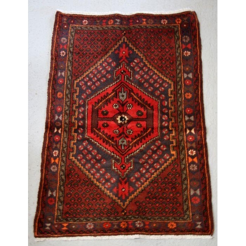 99 - A Persian Hamadan woollen hand knotted rug with central gul within borders, 96 by 140cms (37.5 by 55... 