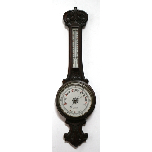 301 - An Edwardian carved oak wheel barometer and thermometer, 25cms diameter.