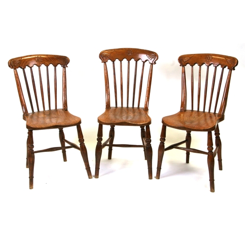 685 - Three elm and fruitwood kitchen chairs on turned legs joined by a stretcher (3).