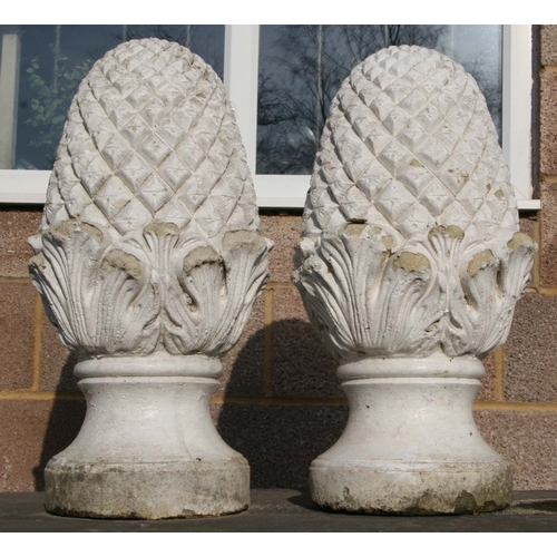 10 - A pair of well weathered painted reconstituted stone pineapple finials, 60cms high (2).