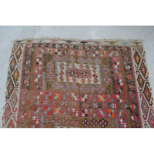 94 - A kilim rug with repeating geometric motifs on a mustard ground within a multi border, 152 by 317cms... 