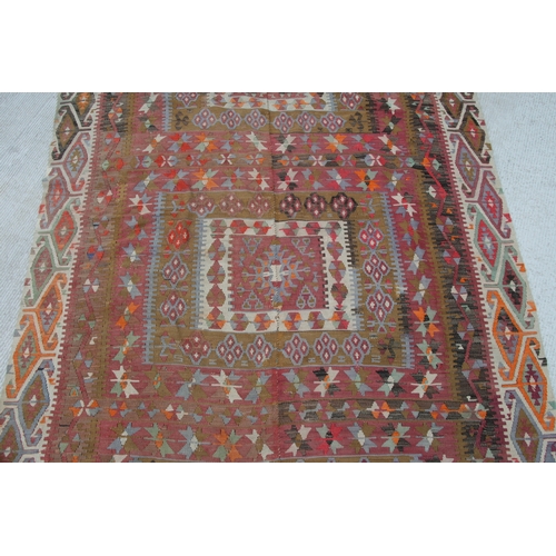 94 - A kilim rug with repeating geometric motifs on a mustard ground within a multi border, 152 by 317cms... 