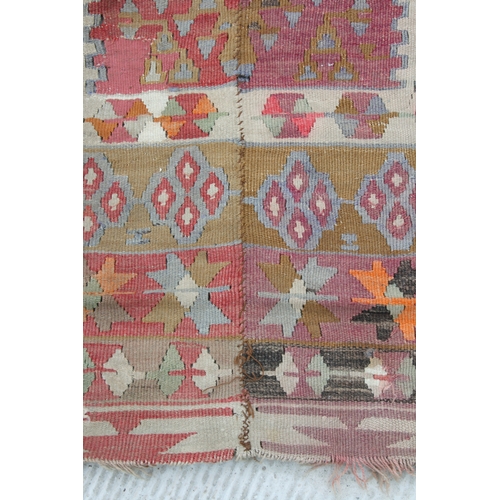 94 - A kilim rug with repeating geometric motifs on a mustard ground within a multi border, 152 by 317cms... 