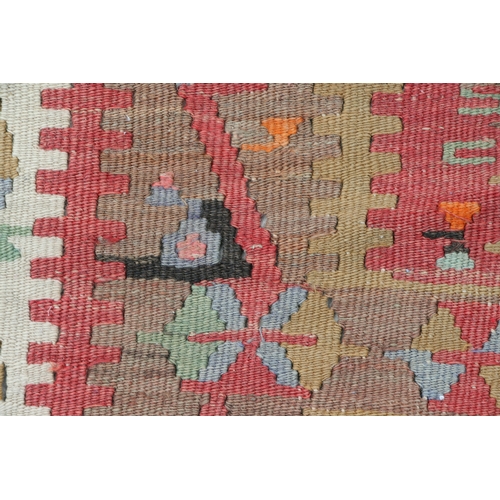 94 - A kilim rug with repeating geometric motifs on a mustard ground within a multi border, 152 by 317cms... 