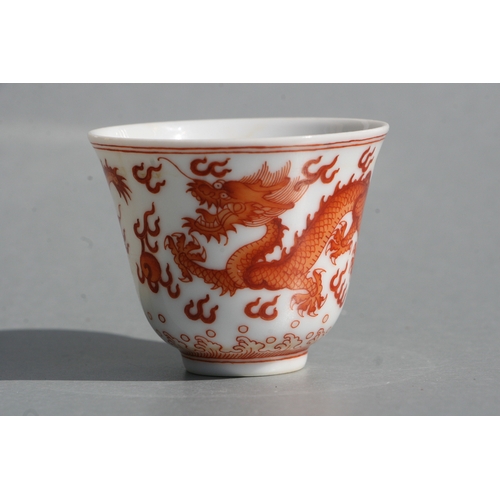 514 - A Chinese red oxide tea bowl decorated with dragons amongst clouds, six character blue mark to the u... 