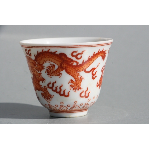 514 - A Chinese red oxide tea bowl decorated with dragons amongst clouds, six character blue mark to the u... 