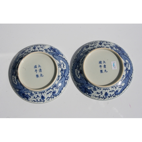 519 - A pair of Chinese blue & white shallow dishes decorated with dragons chasing a flaming pearl amongst... 