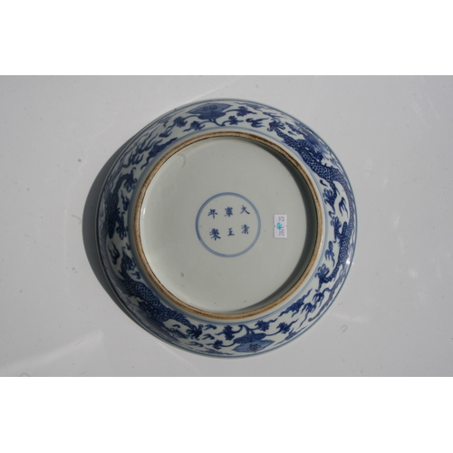 529 - A Chinese blue & white shallow dish decorated with dragons amongst clouds, six character blue mark t... 