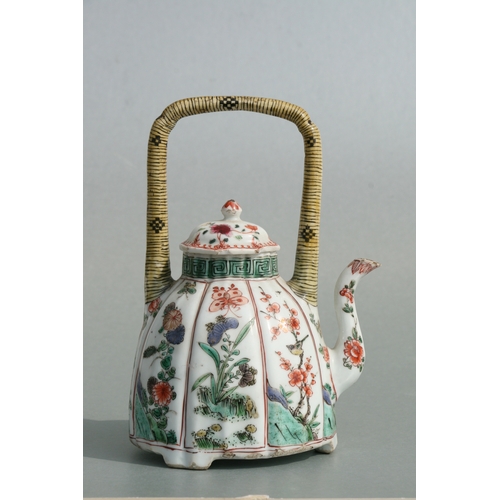 618 - A Chinese famille rose teapot decorated with flowers and insects, 17cms high.