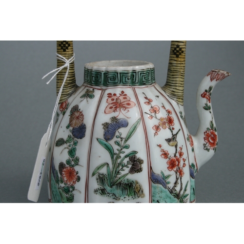 618 - A Chinese famille rose teapot decorated with flowers and insects, 17cms high.