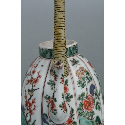 618 - A Chinese famille rose teapot decorated with flowers and insects, 17cms high.