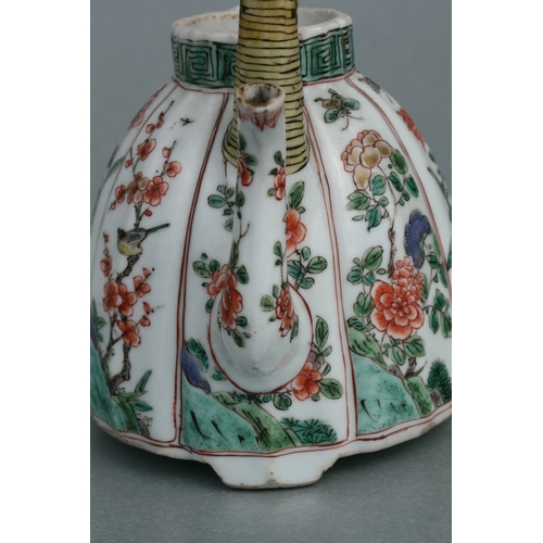 618 - A Chinese famille rose teapot decorated with flowers and insects, 17cms high.