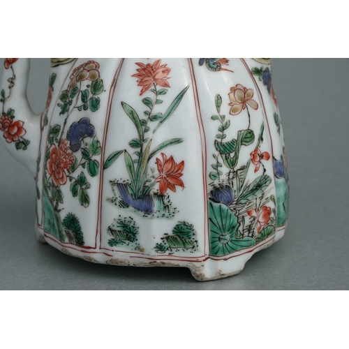 618 - A Chinese famille rose teapot decorated with flowers and insects, 17cms high.