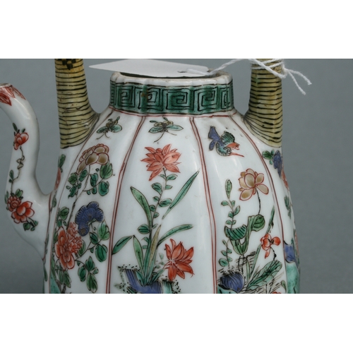 618 - A Chinese famille rose teapot decorated with flowers and insects, 17cms high.