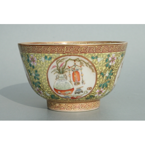 641 - A Chinese famille rose bowl decorated with precious objects within roundels with foliate scrolls on ... 