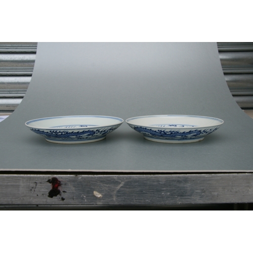 519 - A pair of Chinese blue & white shallow dishes decorated with dragons chasing a flaming pearl amongst... 