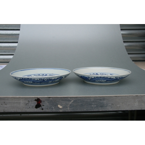 519 - A pair of Chinese blue & white shallow dishes decorated with dragons chasing a flaming pearl amongst... 