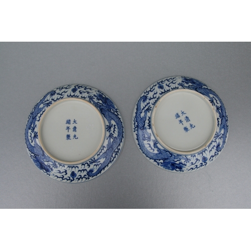 519 - A pair of Chinese blue & white shallow dishes decorated with dragons chasing a flaming pearl amongst... 