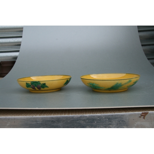 523 - A pair of Chinese shallow bowls, each decorated with dragons chasing a flaming pearl amongst clouds ... 