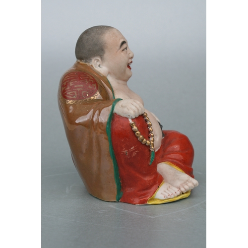 574 - A Chinese figure of a fat Buddha with glazed robes and bisque body, twin impressed seal marks to the... 