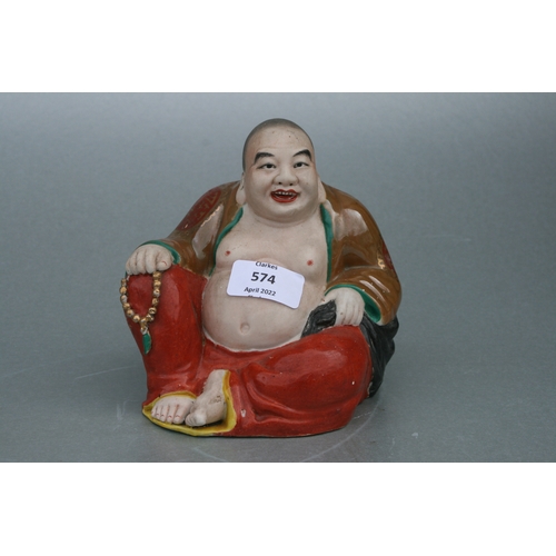 574 - A Chinese figure of a fat Buddha with glazed robes and bisque body, twin impressed seal marks to the... 