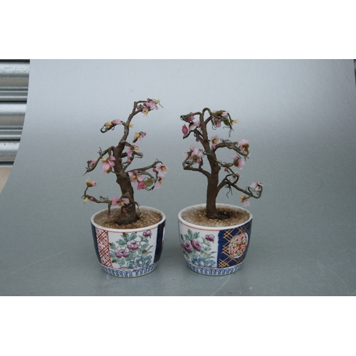 631 - A pair of rectangular form Chinese famille rose planters on stands decorated with precious objects, ... 