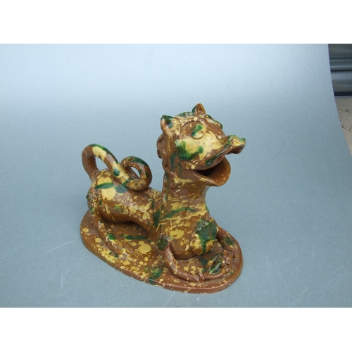 602 - A Turkish Canakkale pottery figure in the form of a stylised recumbent lion, 18cms wide.