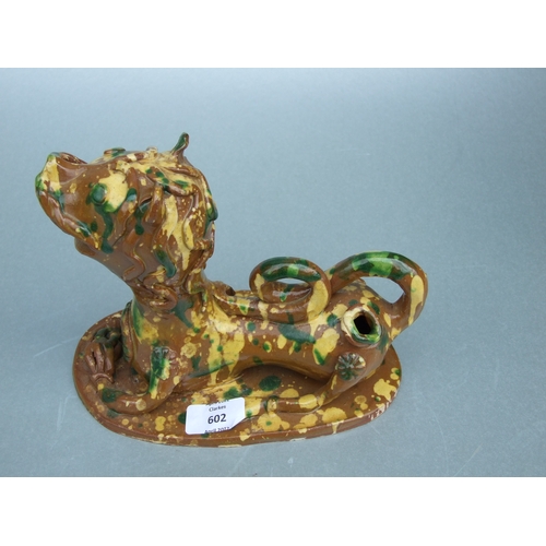 602 - A Turkish Canakkale pottery figure in the form of a stylised recumbent lion, 18cms wide.