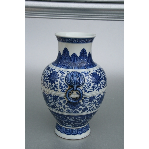 633 - A Chinese blue & white vase with elephant mask handles, decorated with foliate scrolls and waves, bl... 