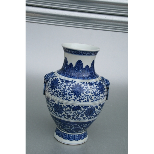 633 - A Chinese blue & white vase with elephant mask handles, decorated with foliate scrolls and waves, bl... 