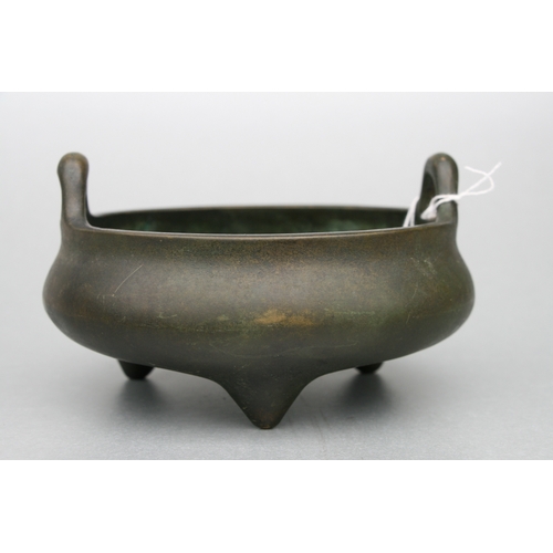 640 - A Chinese bronze two-handled censer on tripod legs, six character mark to the underside, 16cms diame... 