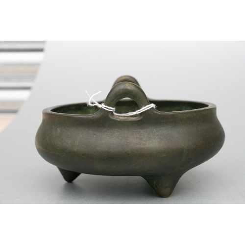 640 - A Chinese bronze two-handled censer on tripod legs, six character mark to the underside, 16cms diame... 