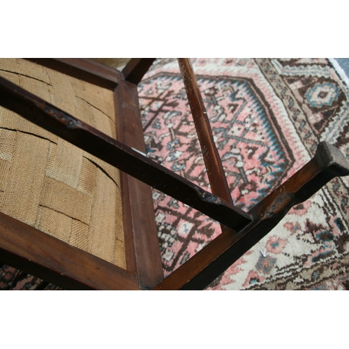 732 - An Arts & Crafts wingback chair with turned spindles, bears plaque 'Goodyer's Regent St & Bond St, L... 