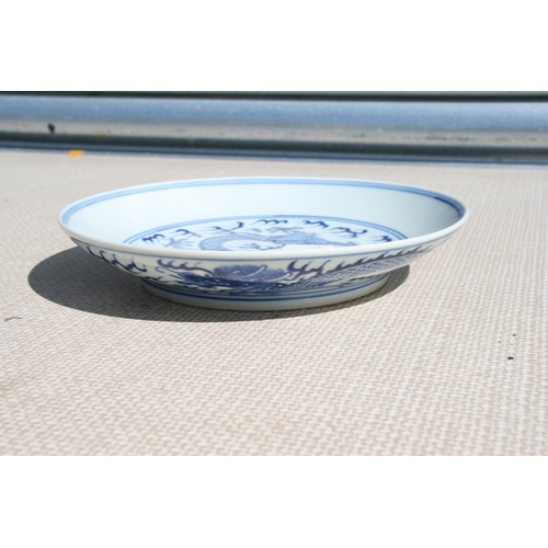 519 - A pair of Chinese blue & white shallow dishes decorated with dragons chasing a flaming pearl amongst... 