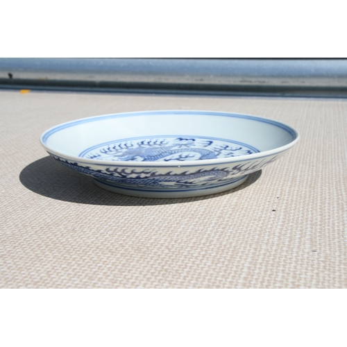 519 - A pair of Chinese blue & white shallow dishes decorated with dragons chasing a flaming pearl amongst... 