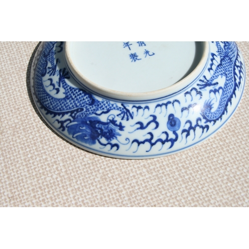 519 - A pair of Chinese blue & white shallow dishes decorated with dragons chasing a flaming pearl amongst... 