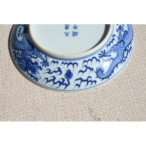 519 - A pair of Chinese blue & white shallow dishes decorated with dragons chasing a flaming pearl amongst... 