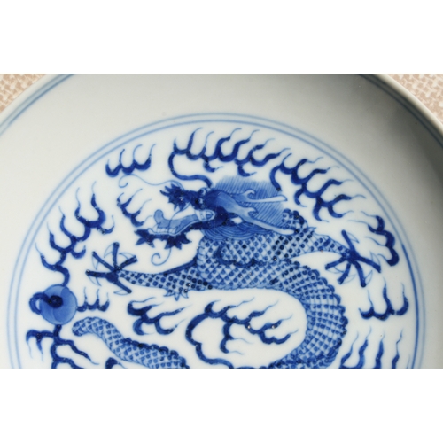 519 - A pair of Chinese blue & white shallow dishes decorated with dragons chasing a flaming pearl amongst... 