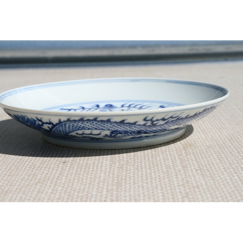 519 - A pair of Chinese blue & white shallow dishes decorated with dragons chasing a flaming pearl amongst... 