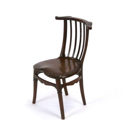 1235 - A child's liberty style mahogany chair with solid heart shaped seat with engraved decoration, on rin... 